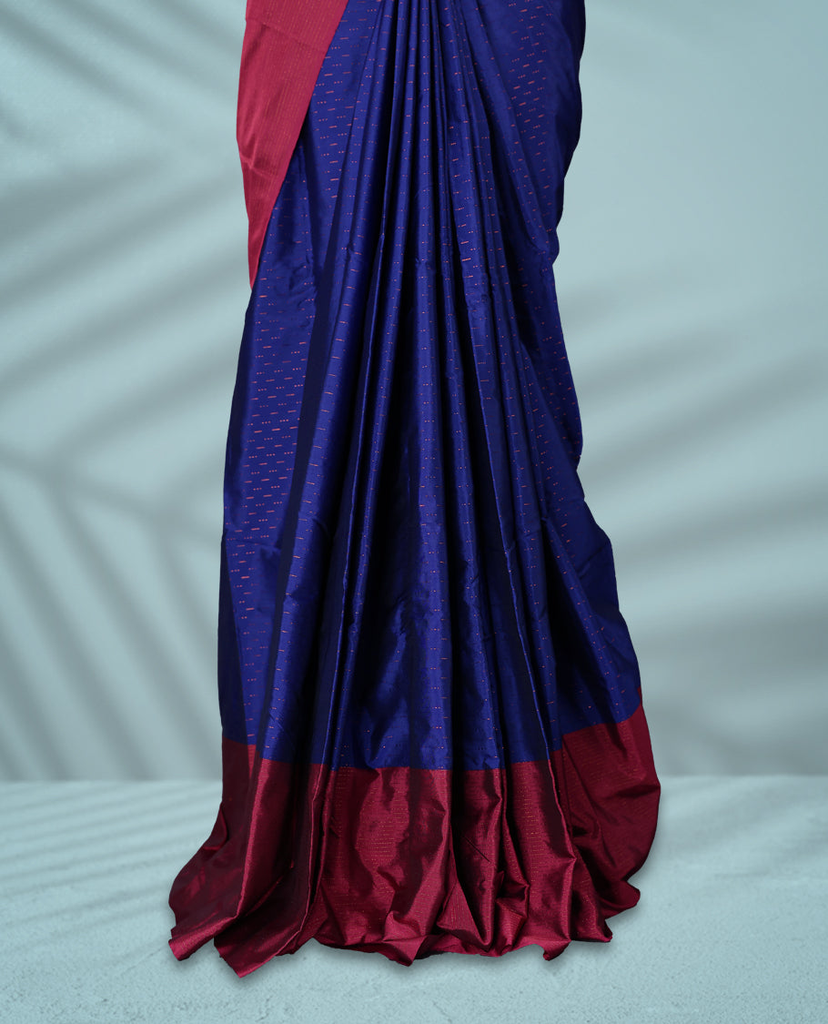 Royal blue Colour semi silk saree is adorned with a subtle copper zari pattern and beautifully offset by a rich wine border, paired with a matching blouse