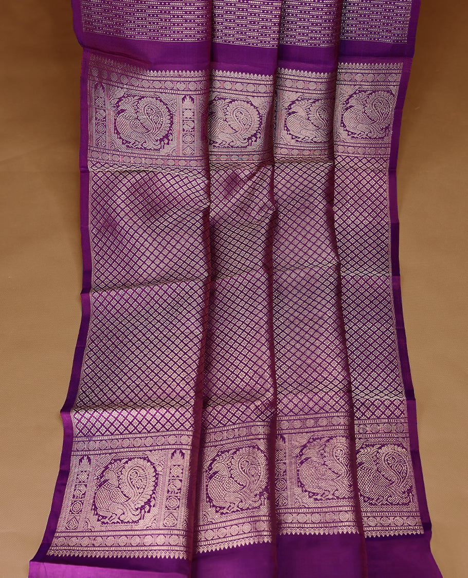 Deep royal purple Colour Kancheepuram designer saree adorned with antique zari large mango motifs, floral kodi work, and vertical gold zari lines on the body, designed without a border, and paired with a matching blouse.