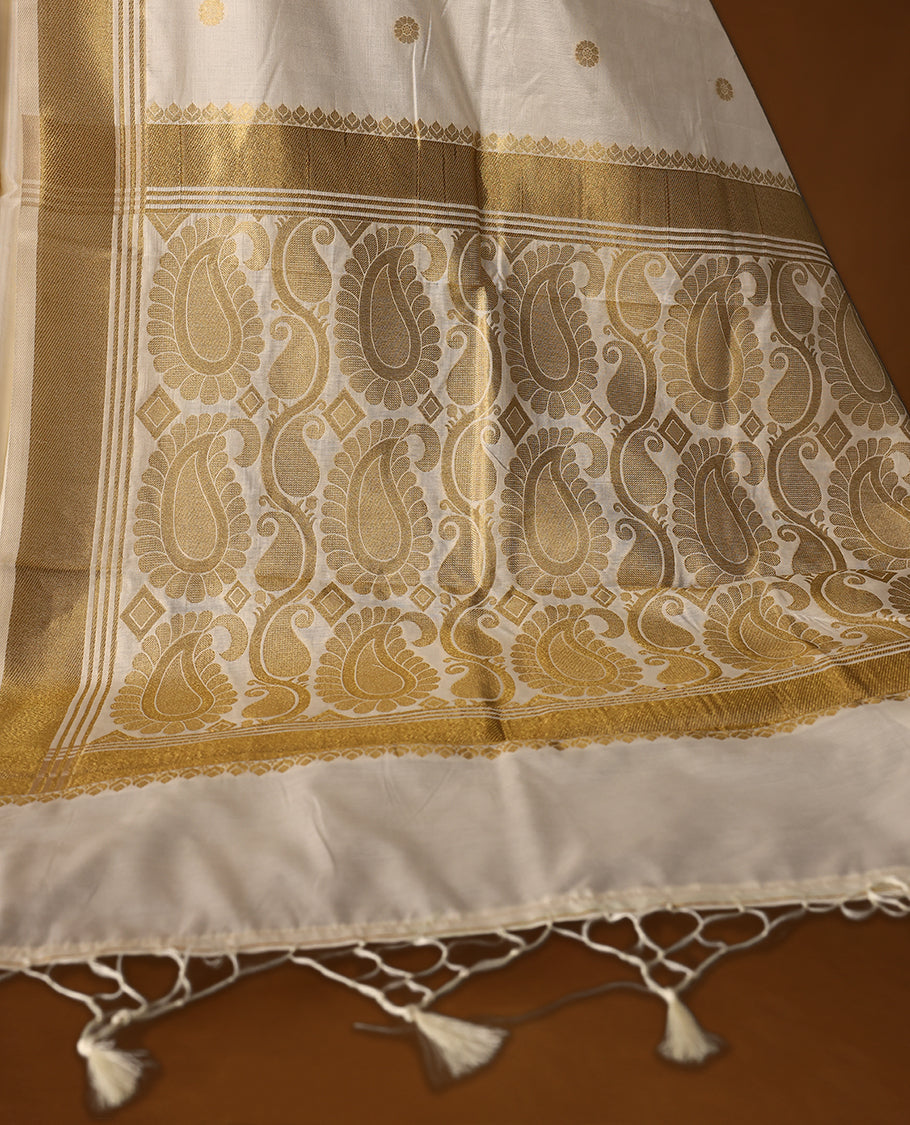 Elegant Kerala Kasavu saree with golden polka motifs and a detailed paisley woven pallu, Finished with tassels, its perfect for festive or traditional wear, Pair with a gold blouse for a classic look.