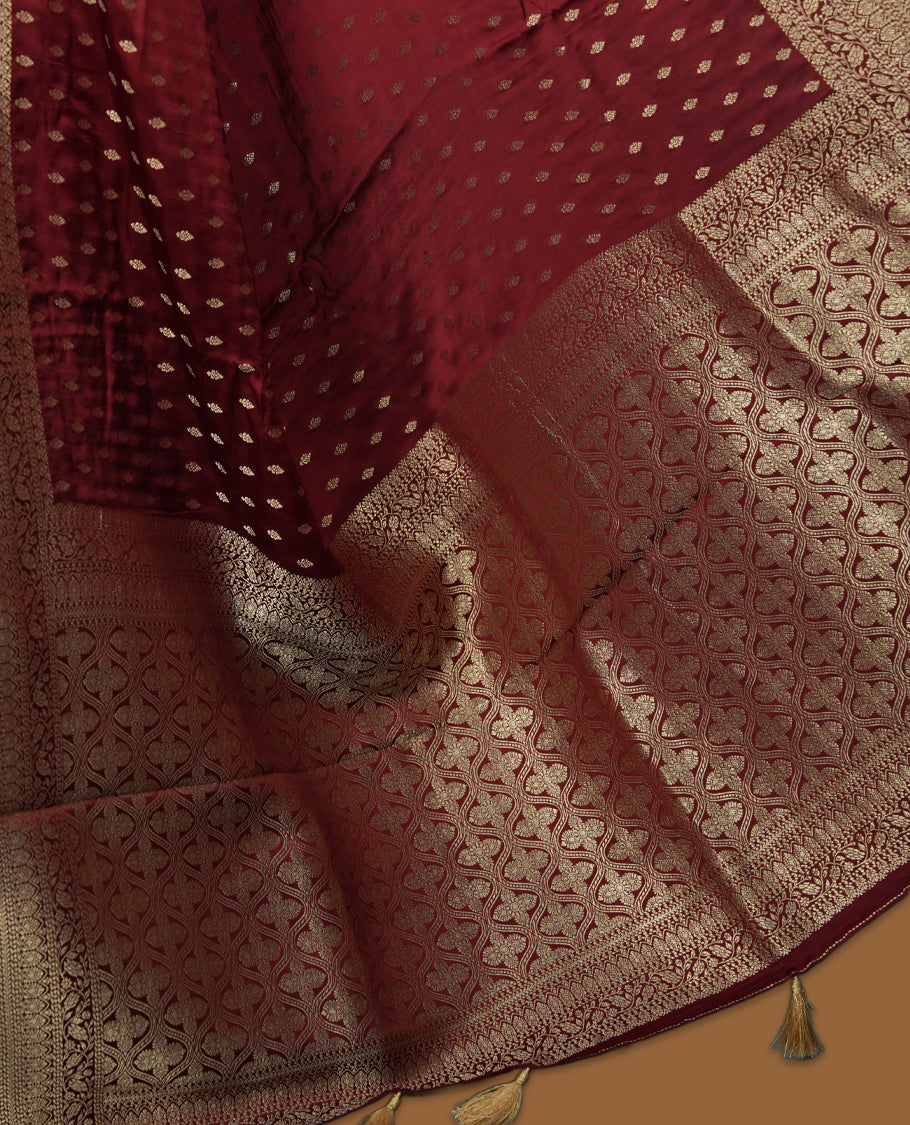 Maroon Colour semi Banaras satin crepe saree with Gold Zari Buti Motifs, Traditional Gold Geometric Pallu, Elaborate Woven Border, Decorative Tassels with Matching Blouse
