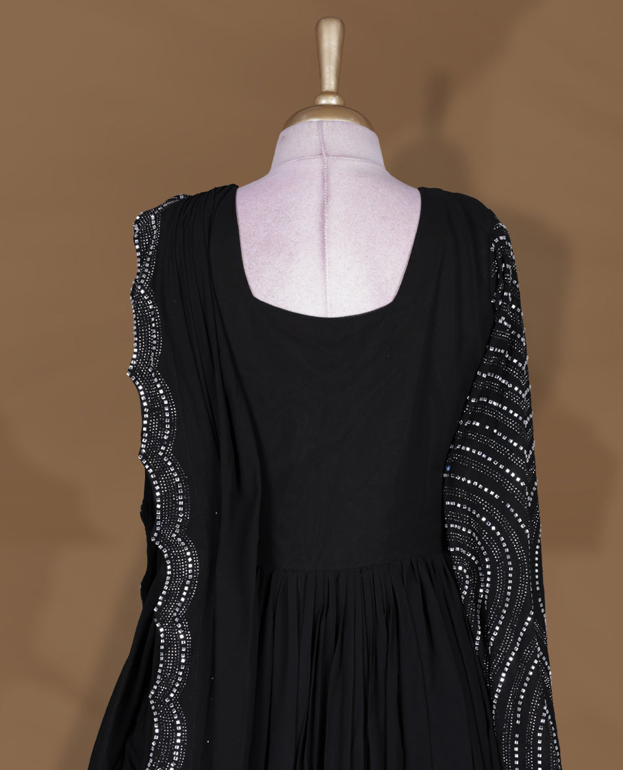 Black colour stitched gown set with sleeveless square‑neck bodice, attached pleated flare, and one‑side draped dupatta highlighted with heavy silver sequin and mirror work borders.