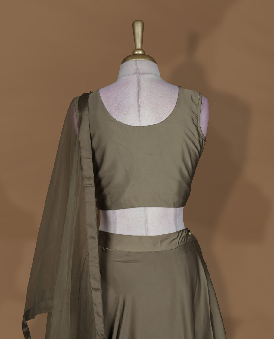 Olive brown colour lehenga set with stitched sleeveless embroidered blouse, matching stitched flared lehenga, and plain sheer dupatta with satin border.