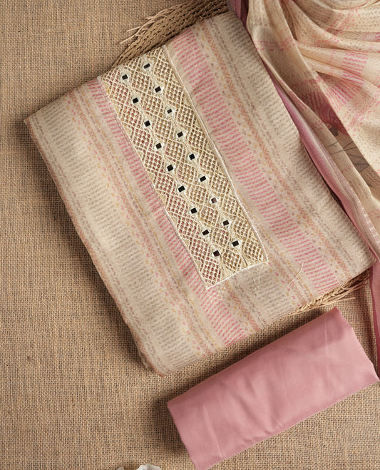 Pastel pink and beige colour suit material with delicate woven mirror work patterns and subtle zari detailing & Includes a soft dupatta with a floral touch and plain matching bottom.