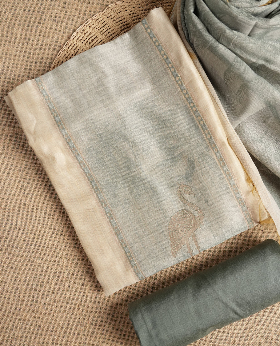 Beige & Pastel green colour suit material adorned with intricate woven patterns, bird print & subtle motifs, exuding ethnic grace & paired with a beautifully bordered dupatta and a matching plain bottom.
