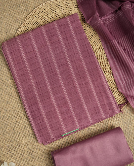 Mauve colour tussar suit material featuring a subtle self woven pattern and vertical lines on the body, paired with a lightweight matching dupatta with tassel edges and a plain bottom piece.