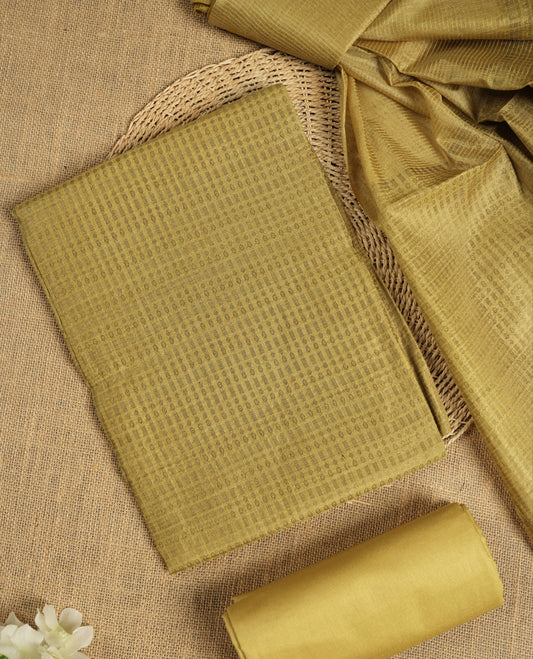 Citrine yellow tussar suit material featuring a subtle self check woven pattern on the body, paired with a lightweight matching dupatta with tassel edges and a plain bottom piece.