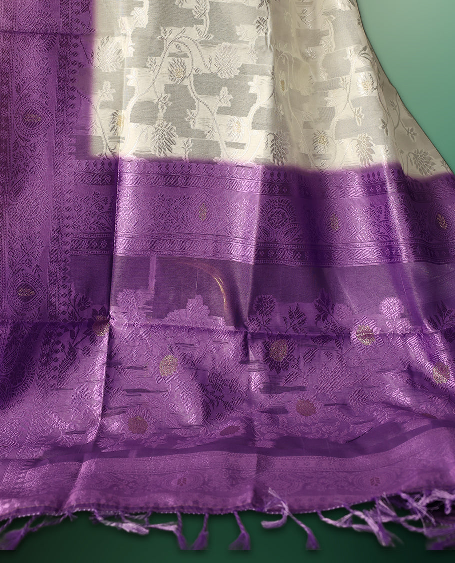 White colour saree adorned with delicate self woven motifs across the body, highlighted with a striking Purple woven border and pallu, finished with tassels, and paired with a matching blouse