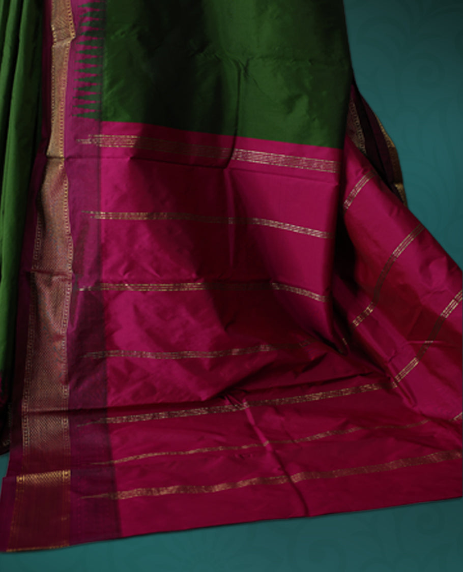 Deep green semi silk saree with plain body, vibrant deep magenta pallu and matching magenta border adorned with golden zari, accented with temple motifs along the edges, Paired with a matching blouse, perfect for festive occasions.