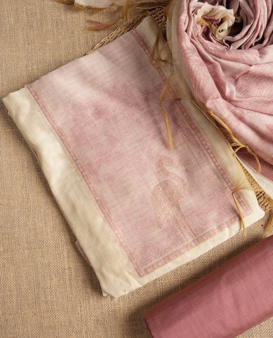 Beige & Onion pink colour suit material adorned with intricate woven patterns, bird print & subtle motifs, exuding ethnic grace & paired with a beautifully bordered dupatta and a matching plain bottom.