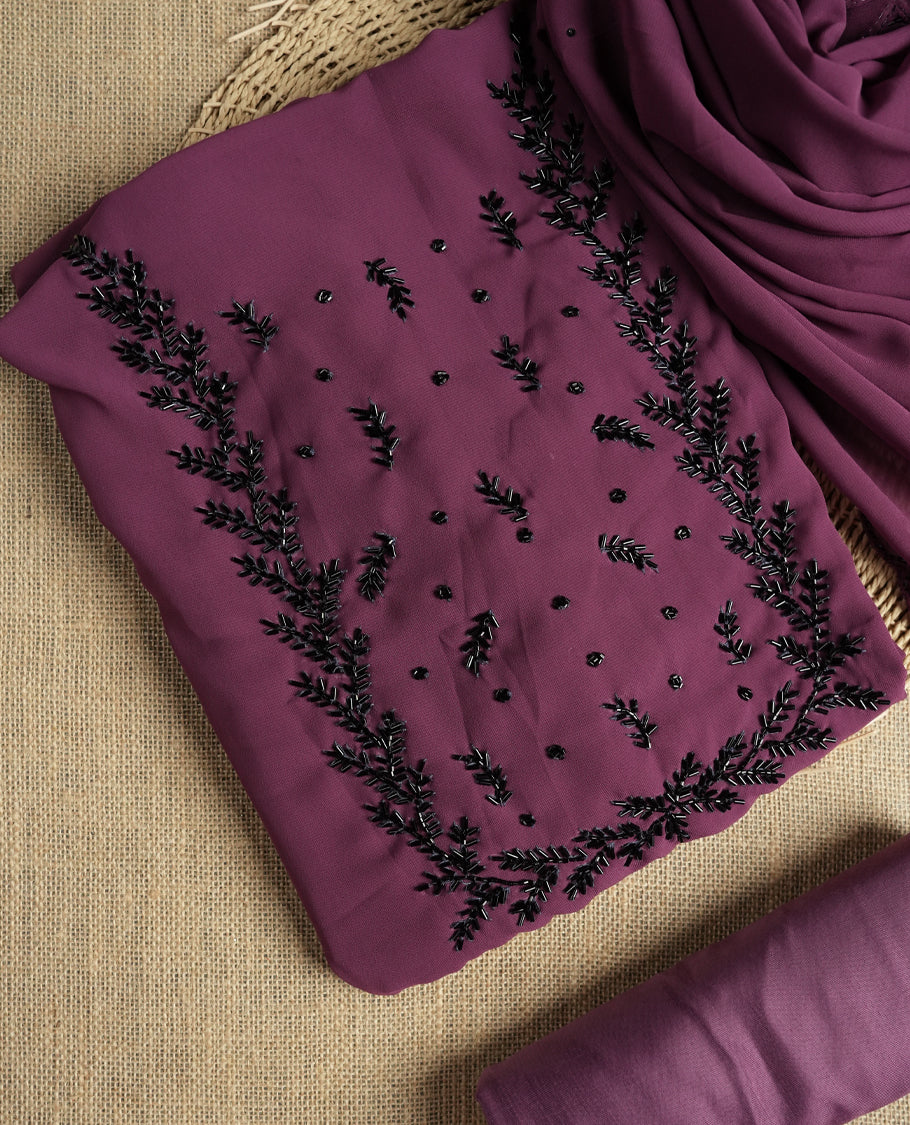 Elegant dark mauve colour suit material adorned with intricate black cut beads work, exuding sophisticated charm & paired with a soft dupatta and a matching plain bottom.