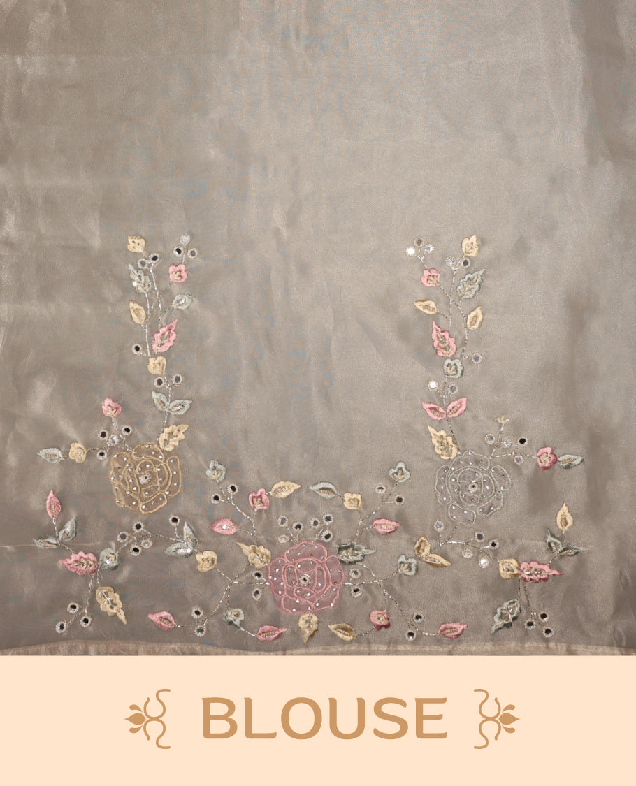 Beige Colour organza saree featuring delicate floral embroidery with applique, bead, mirror, and thread detailing on the body and scalloped border, lending a soft feminine charm, paired with a matching blouse.