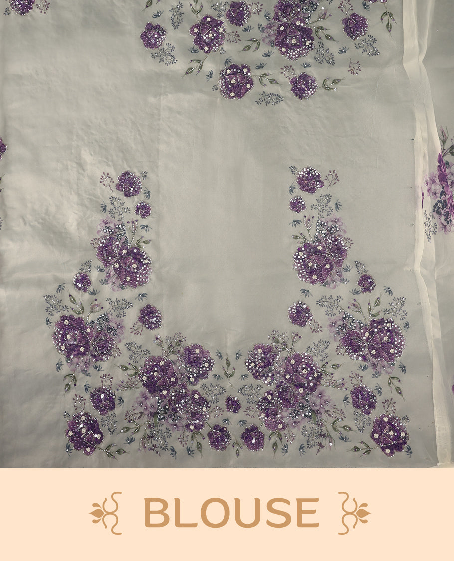 White colour pure organza saree featuring purple Colour floral prints with intricate bead and sequin work across the body, adorned with a matching embellished border, complemented by a worked pallu and paired with a heavily worked matching blouse.