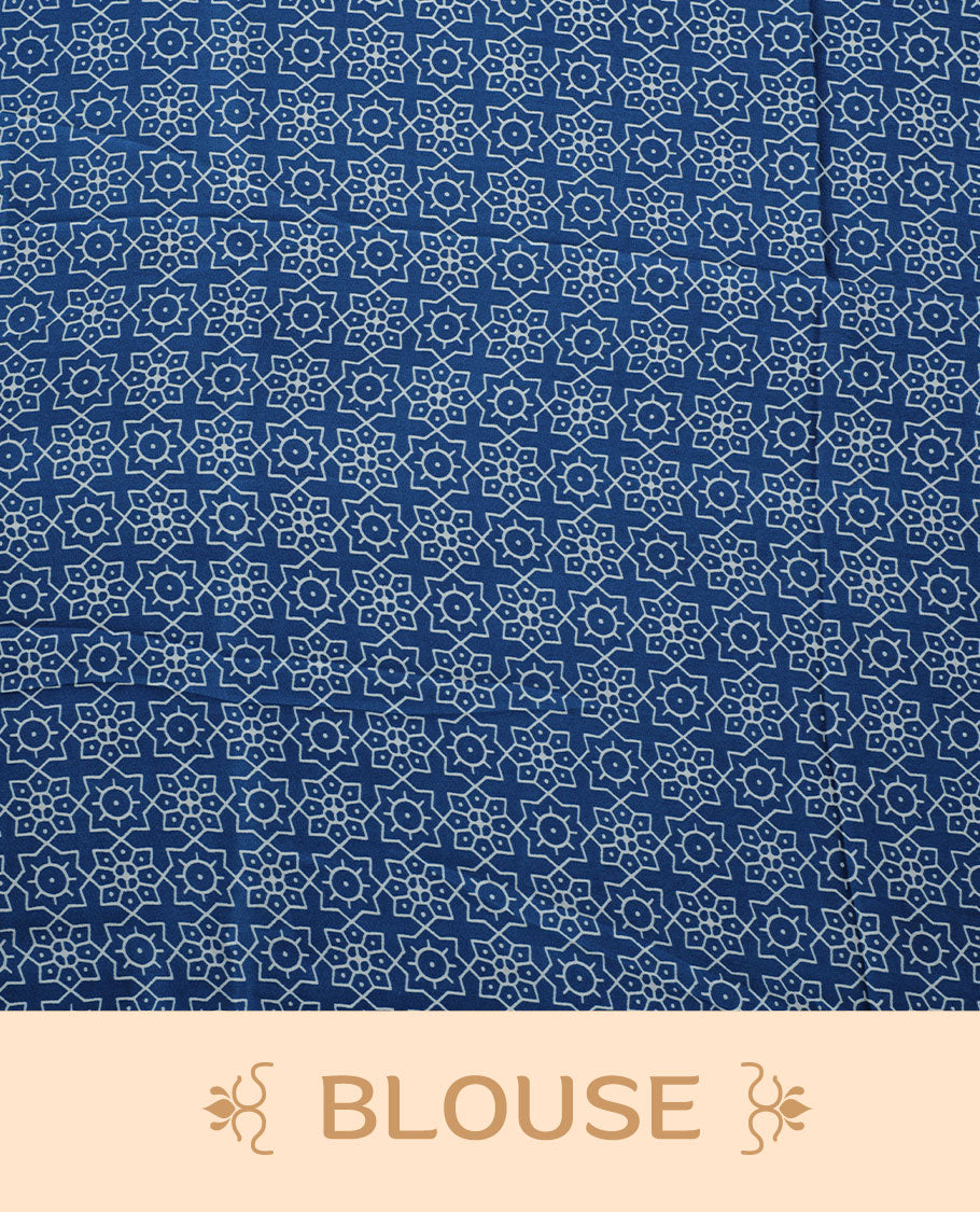 Blue colour semi modal saree highlighted with white triangle border accents and sleek striped detailing across the drape, featuring a bold oversized white circular motif on the pallu, paired with a matching printed blouse.