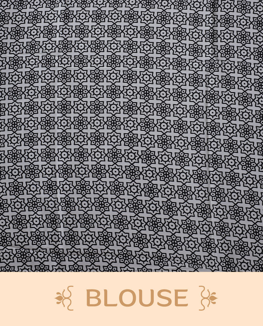 White colour semi modal saree highlighted with black triangle border accents and sleek striped detailing across the drape, featuring a bold oversized black circular motif on the pallu, paired with a matching printed blouse.