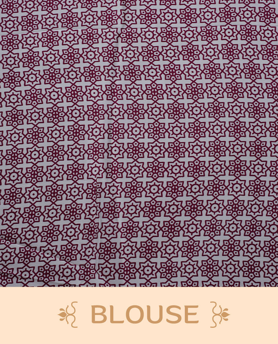 White colour semi modal saree featuring wine berry colour geometric borders and fine stripe detailing, finished with an oversized circular motif on the pallu, paired with a matching printed blouse.