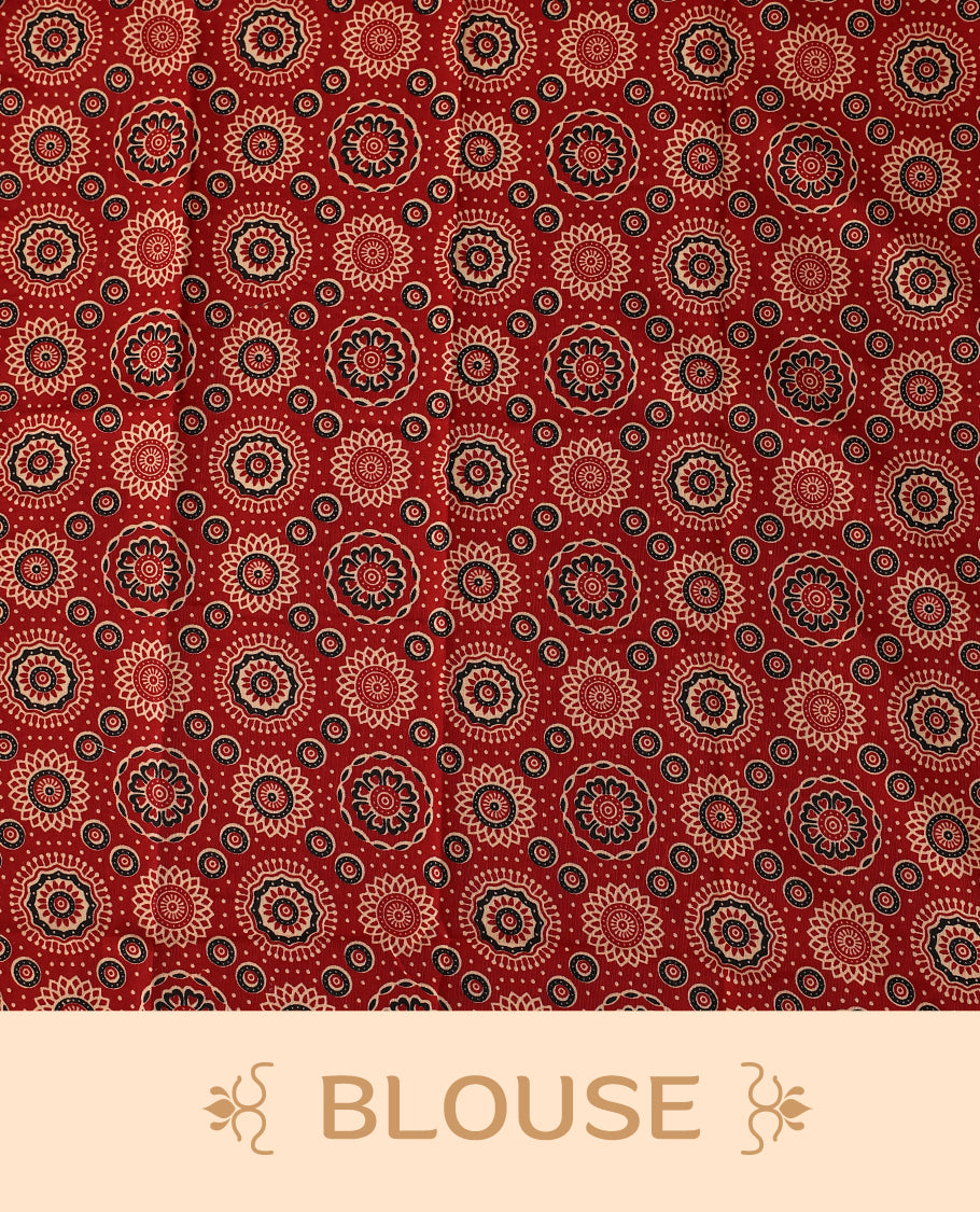 off white saree with a striking red printed border. The border features circular floral motifs in black and cream, with dotted detailing radiating outward, creating a traditional yet vibrant design