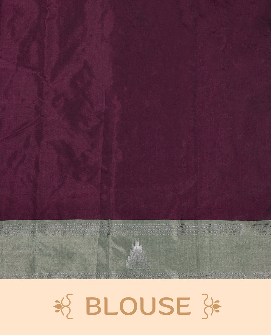 Burgundy Colour semi silk saree features an all over silver zari pattern and a sage green border adorned with traditional temple motifs, paired with a matching blouse.