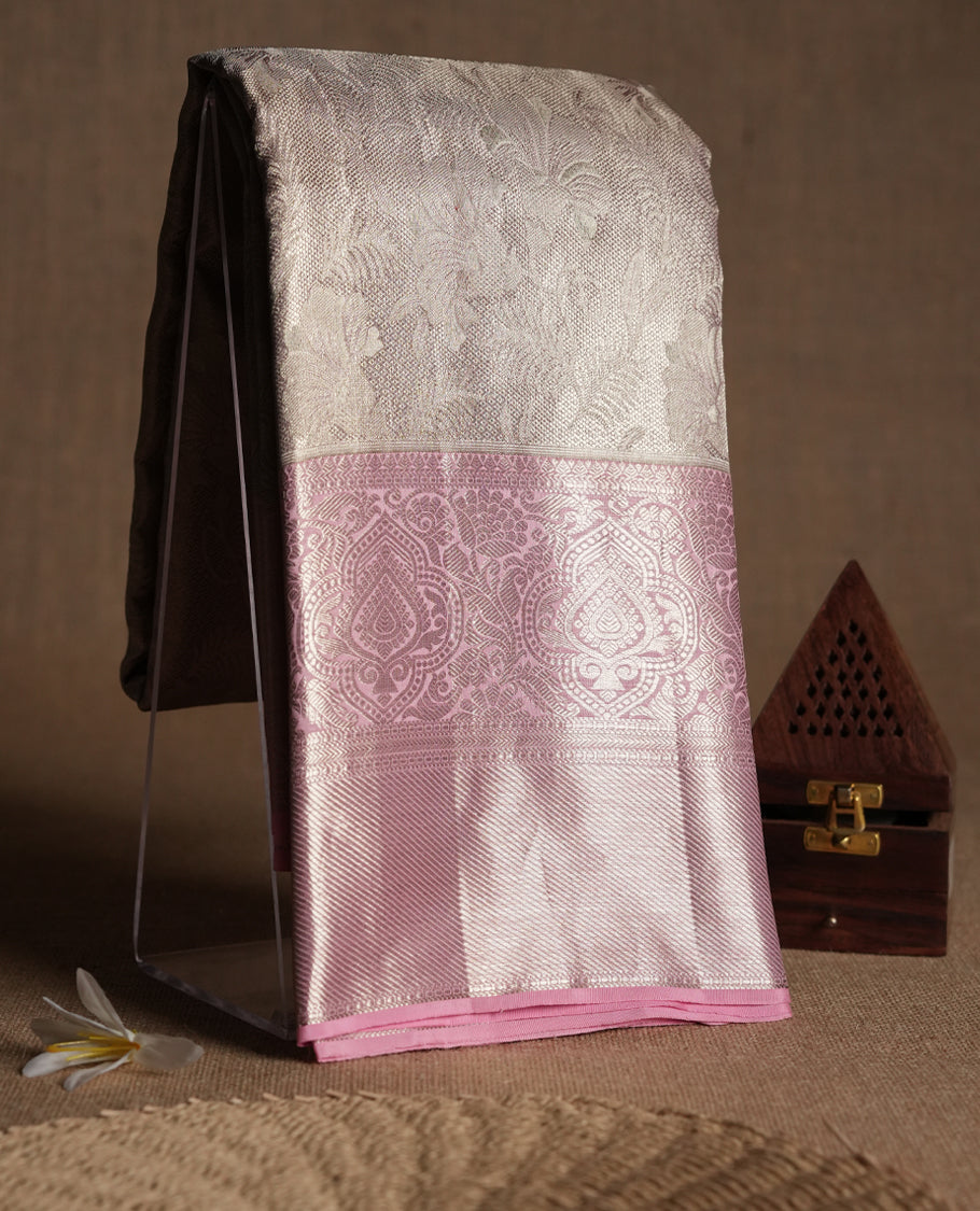 Baby pink Colour Kancheepuram tissue silk saree featuring intricate silver zari floral work on the body, complemented by a contrasting traditional border and a matching blouse.
