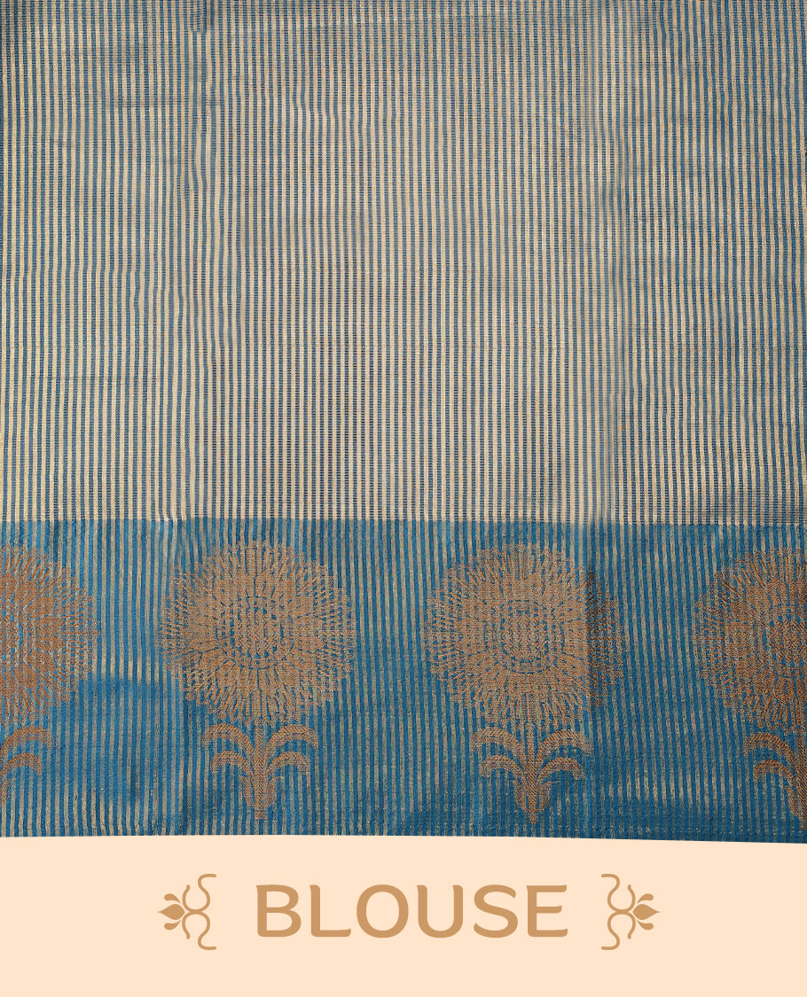Blue Colour Semi Tussar Silk saree featuring golden zari horizontal lines across the body, adorned with bold floral motifs on the border, paired with a matching blouse.