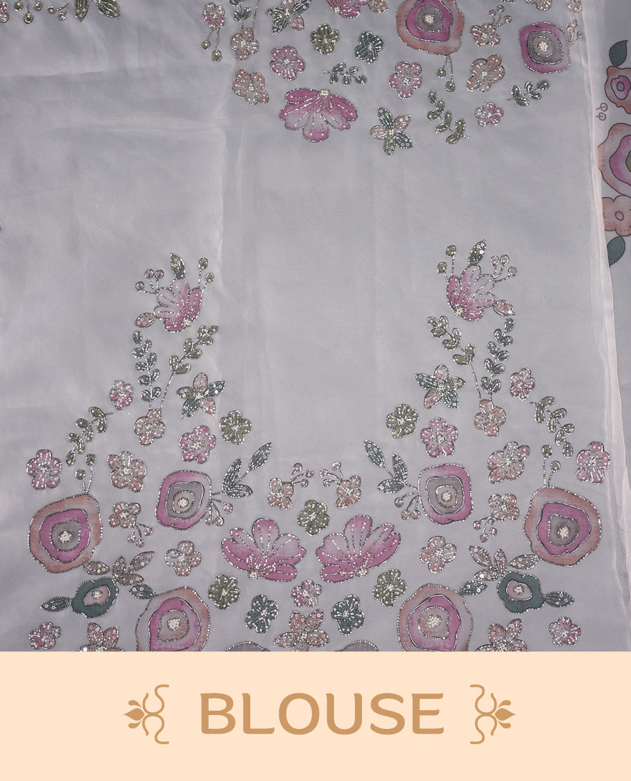 White colour pure organza saree featuring Multi Colour floral prints with intricate bead and sequin work across the body, adorned with a matching embellished border, complemented by a worked pallu and paired with a heavily worked matching blouse.