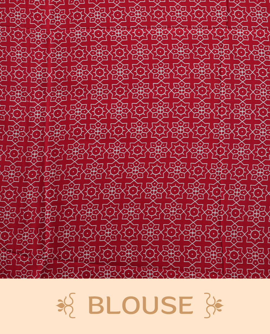 Red colour semi modal saree featuring white colour geometric borders and fine stripe detailing, finished with an oversized circular motif on the pallu, paired with a matching printed blouse.
