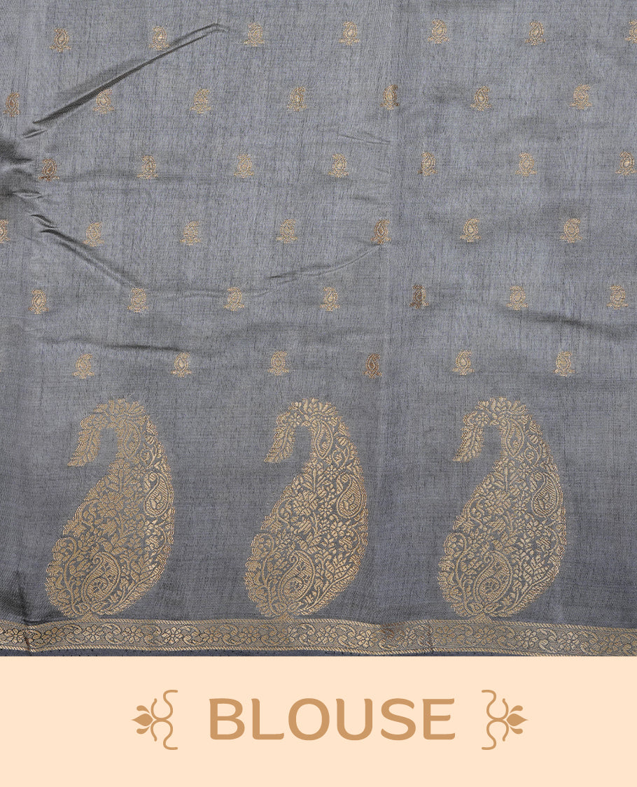 Grey colour semi tussar silk saree featuring small gold zari mango motifs across the body, enhanced with a self colour border showcasing elegant gold zari mango patterns. Paired with a matching blouse piece.