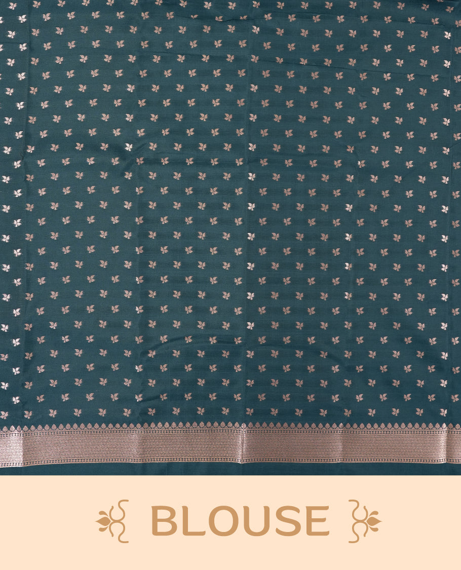 Dark teal blue colour semi silk saree adorned with elegant floral motifs on the body, complemented by a shimmering golden zari-woven pallu and border, and paired with a matching blouse