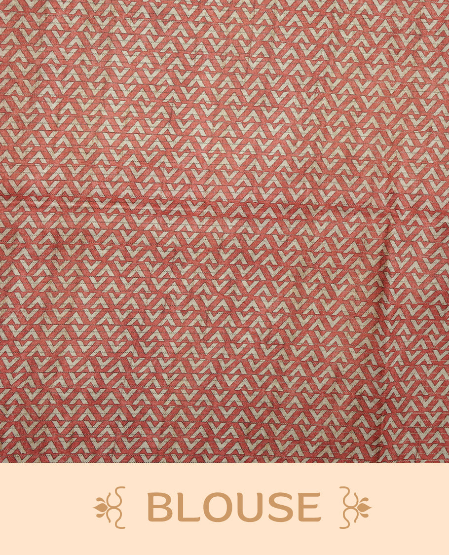Rust brown colour semi tussar silk saree featuring bold zigzag geometric prints across the body, highlighted with a contrasting coral-red border and detailed pallu, paired with a matching printed blouse piece.