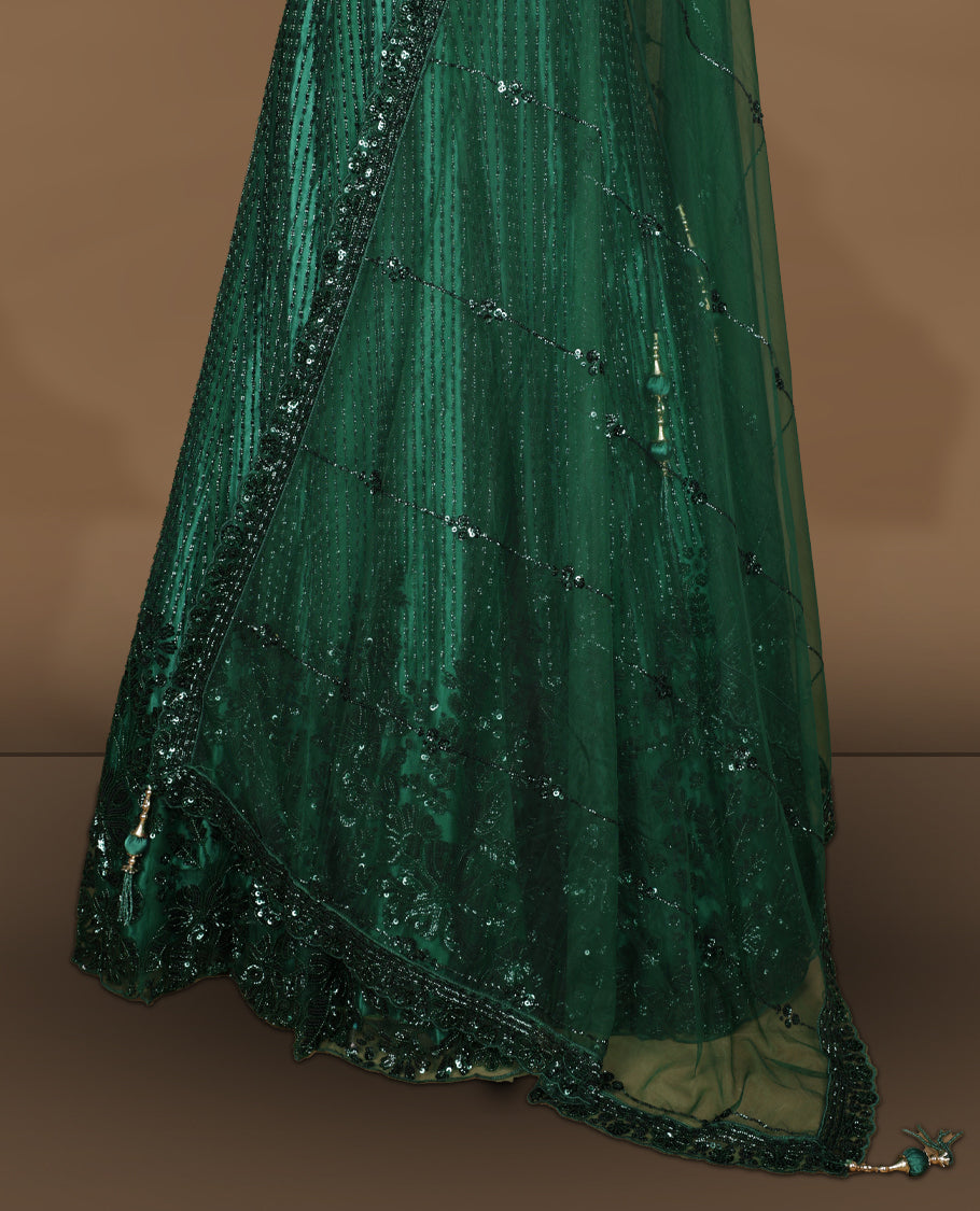 Emerald green colour lehenga set with stitched sleeveless V‑neck heavily sequinned blouse featuring cut‑out tie‑up back, matching stitched flared lehenga, and net dupatta with sequin border and scattered floral motifs.