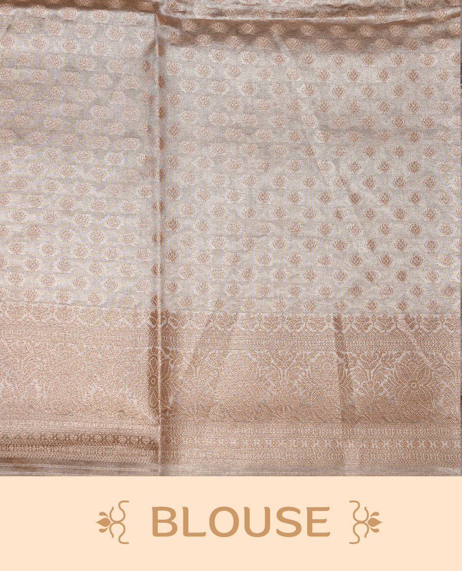 Pastel grey colour semi tissue silk saree featuring floral zari motifs on body, complemented by gold zari traditional border, paired with matching blouse piece.
