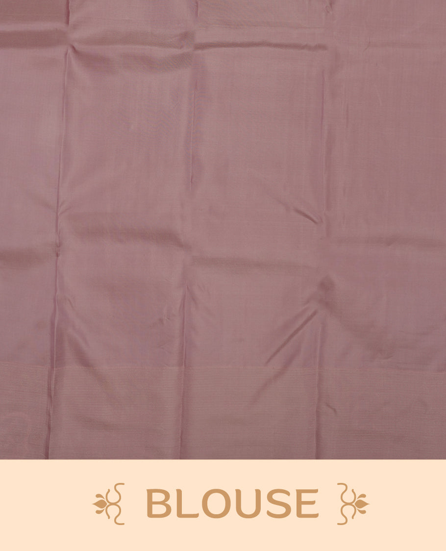 Dusty lavender colour Vasundhara silk saree adorned with all-over self color leaf kodi motifs on the body, complemented by a self colour with gold line pattern border and paired with a matching blouse piece.