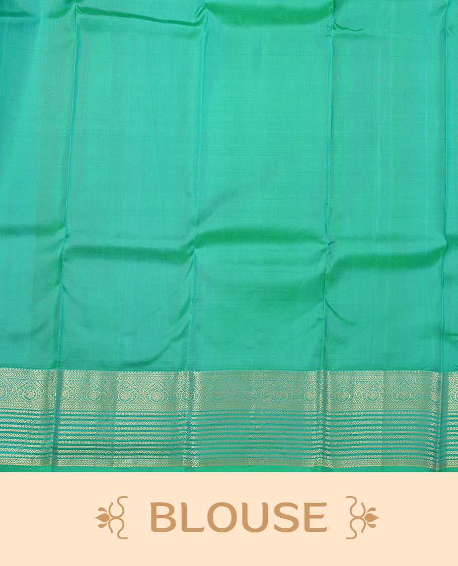 Dark purple colour Vasundhara silk saree adorned with all-over gold motifs on the body, complemented by a contrast green with gold tarditional border and paired with a matching blouse piece.