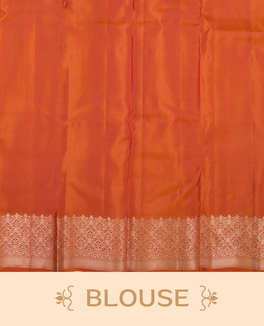 Burnt orange colour Vasundhara silk saree adorned with all-over gold motifs on the body, complemented by a self colour with gold tarditional border and paired with a matching blouse piece.