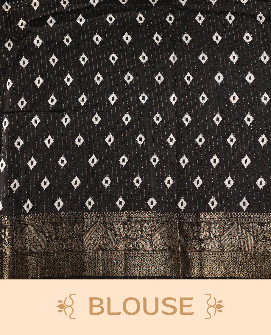 White colour saree adorned with intricate floral patterns across the body, enhanced by a rich black and gold zari border, featuring a vibrant artistic pallu with tree and nature motifs, paired with a matching blouse.