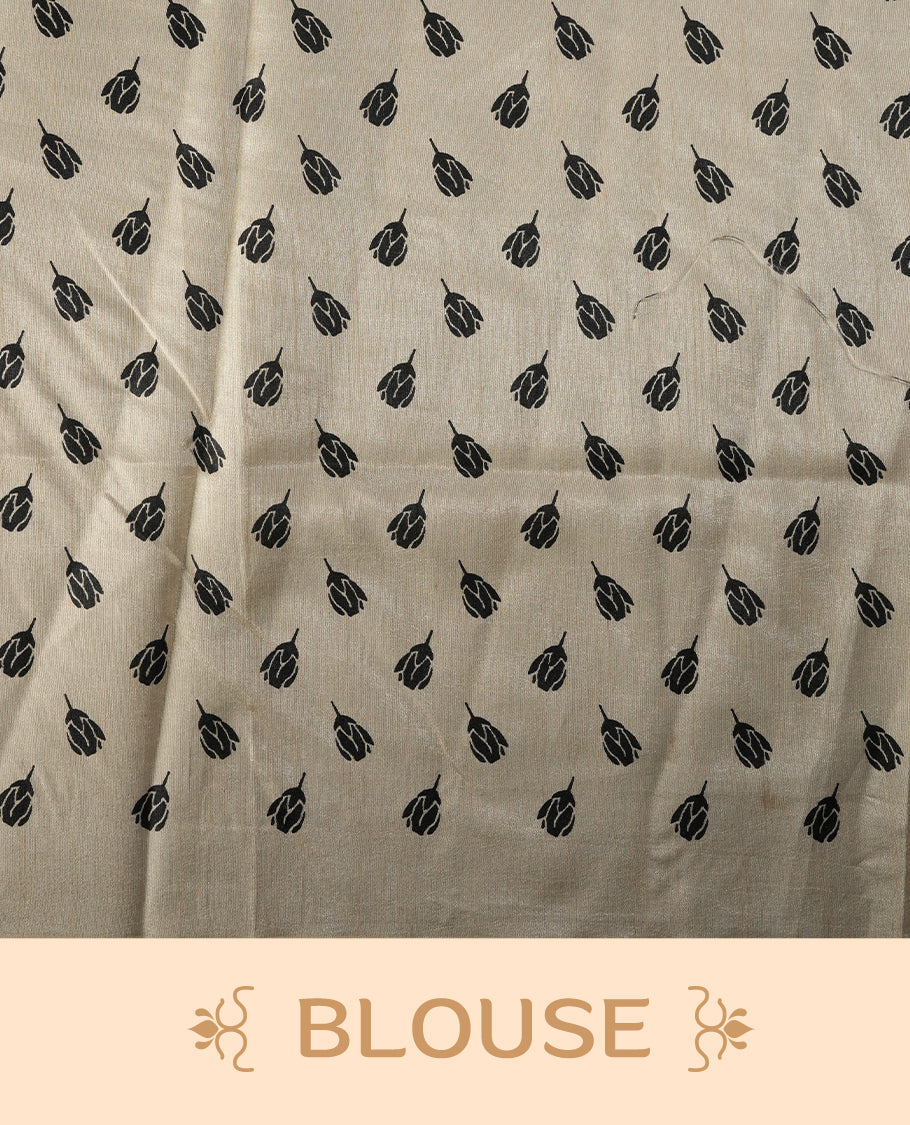 Beige colour saree adorned with black floral prints across the body, complemented by a striking black pallu with floral and stripe detailing. Finished with a subtle border and paired with a matching blouse.