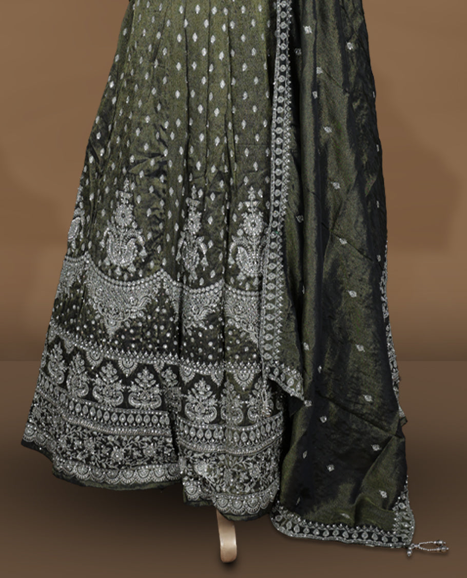 Olive green and black ombre effect lehenga set with stitched sleeveless V‑neck heavily embroidered blouse, matching stitched flared lehenga featuring intricate zari and sequin borders, and coordinated dupatta with embellished edge.
