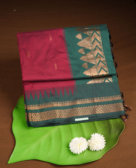 Maroon colour kalyani cotton saree featuring gold zari motifs on body, complemented by contrast maroon color with gold zari pattern border , paired with matching blouse piece.