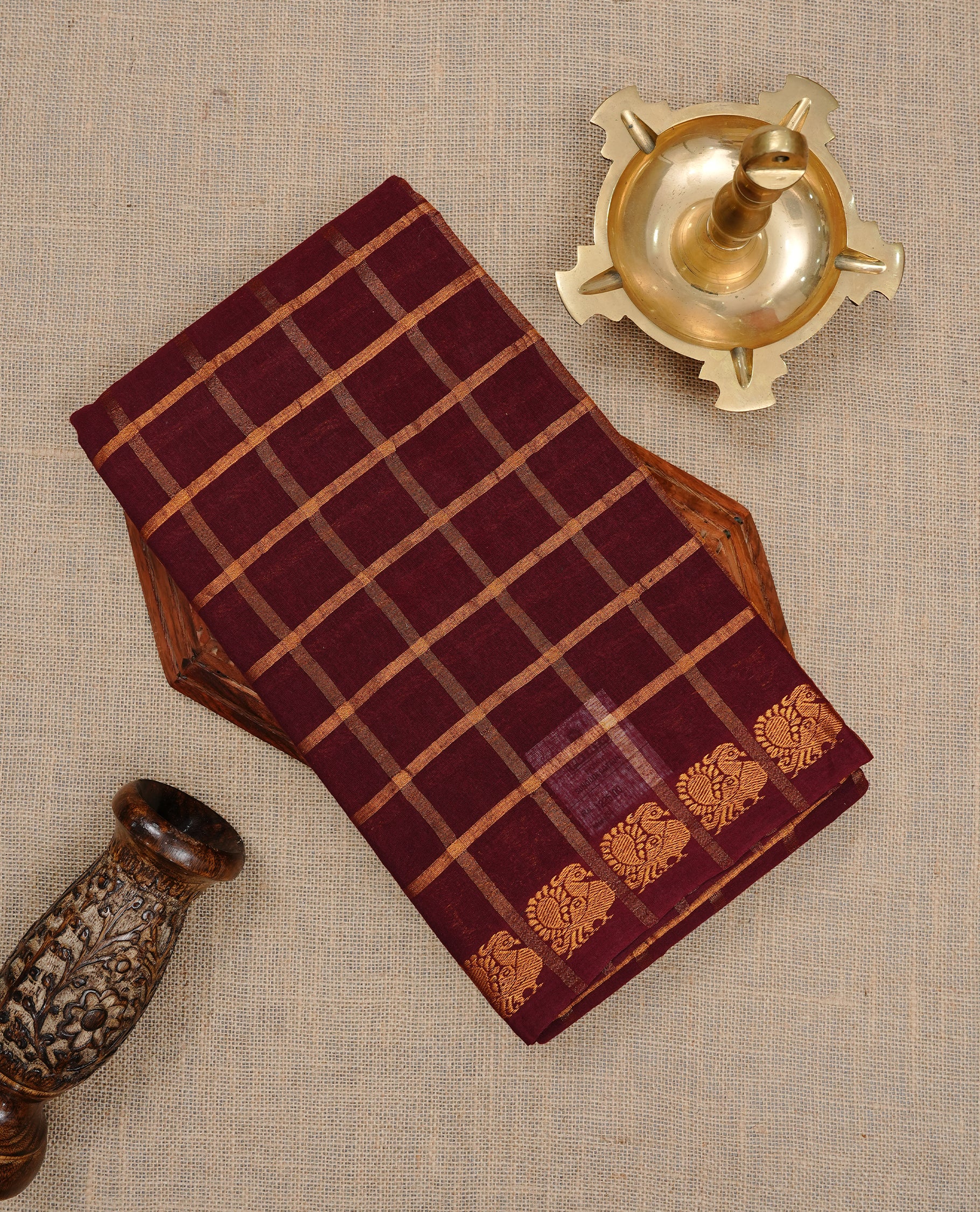 Maroon colour Sungudi cotton saree featuring Gold zari Check pattern on body, Gold zari Peacock design on Self colour border, paired with matching blouse piece.