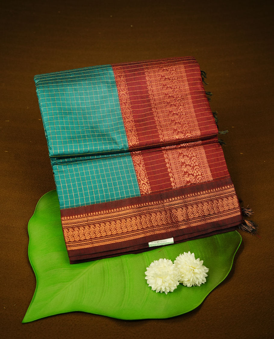 Teal green colour kalyani cotton saree featuring gold zari check pattern on body, complemented by Maroon colour with Antique zari border, paired with matching blouse piece.