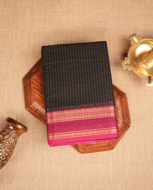 Black colour chettinad cotton featuring gold zari check pattern on body , complemented by contrast teal & magenta double colour with gold zari border, paired with matching blouse piece.