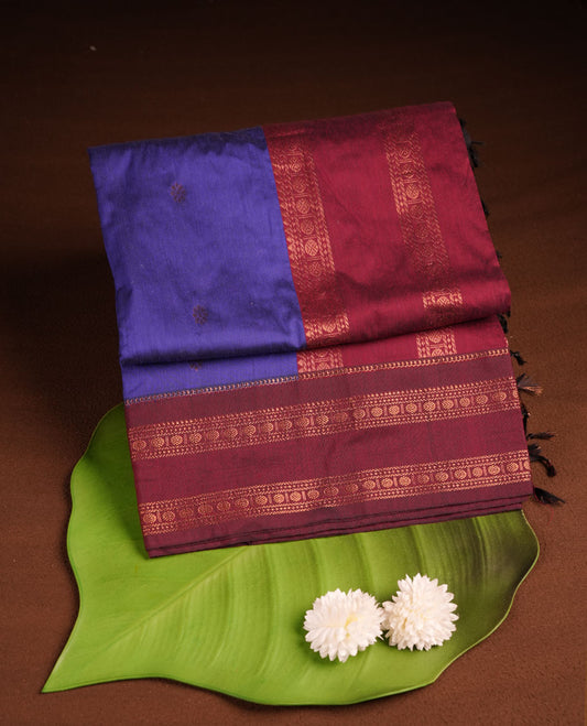Navy blue colour kalyani cotton saree featuring gold zari motifs on body, complemented by contrast maroon color with copper zari pattern border , paired with matching blouse piece.