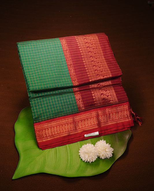 Green colour kalyani cotton saree featuring gold zari check pattern on body, complemented by Maroon colour with Antique zari border, paired with matching blouse piece.