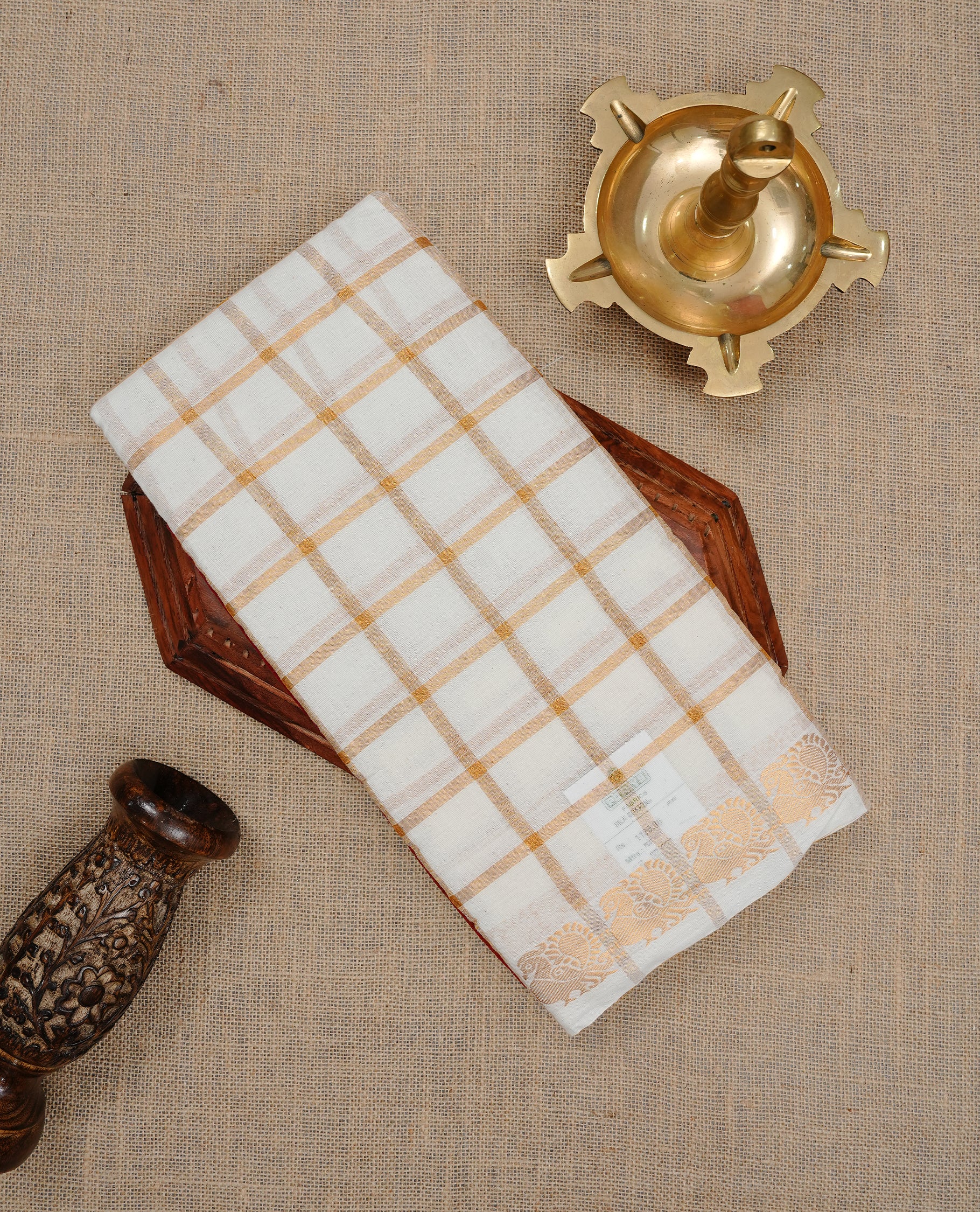 Off white colour Sungudi cotton saree featuring Gold zari checks on body, Gold zari Peacock design on Self colour border, paired with matching blouse piece.