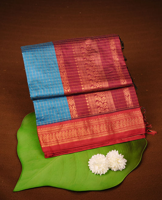 Blue colour kalyani cotton saree featuring gold zari check pattern on body, complemented by Maroon colour with Antique zari border, paired with matching blouse piece.