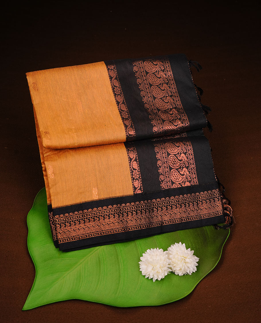 Mustard colour kalyani cotton saree featuring Elegant plain body, complemented by Black colour with Antique zari border, paired with matching blouse piece.