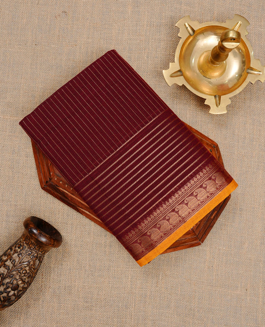 Maroon colour Chettinad cotton saree featuring gold zari stripes on body , complemented by contrast Magenta colour with zari border, comes with matching blouse piece.