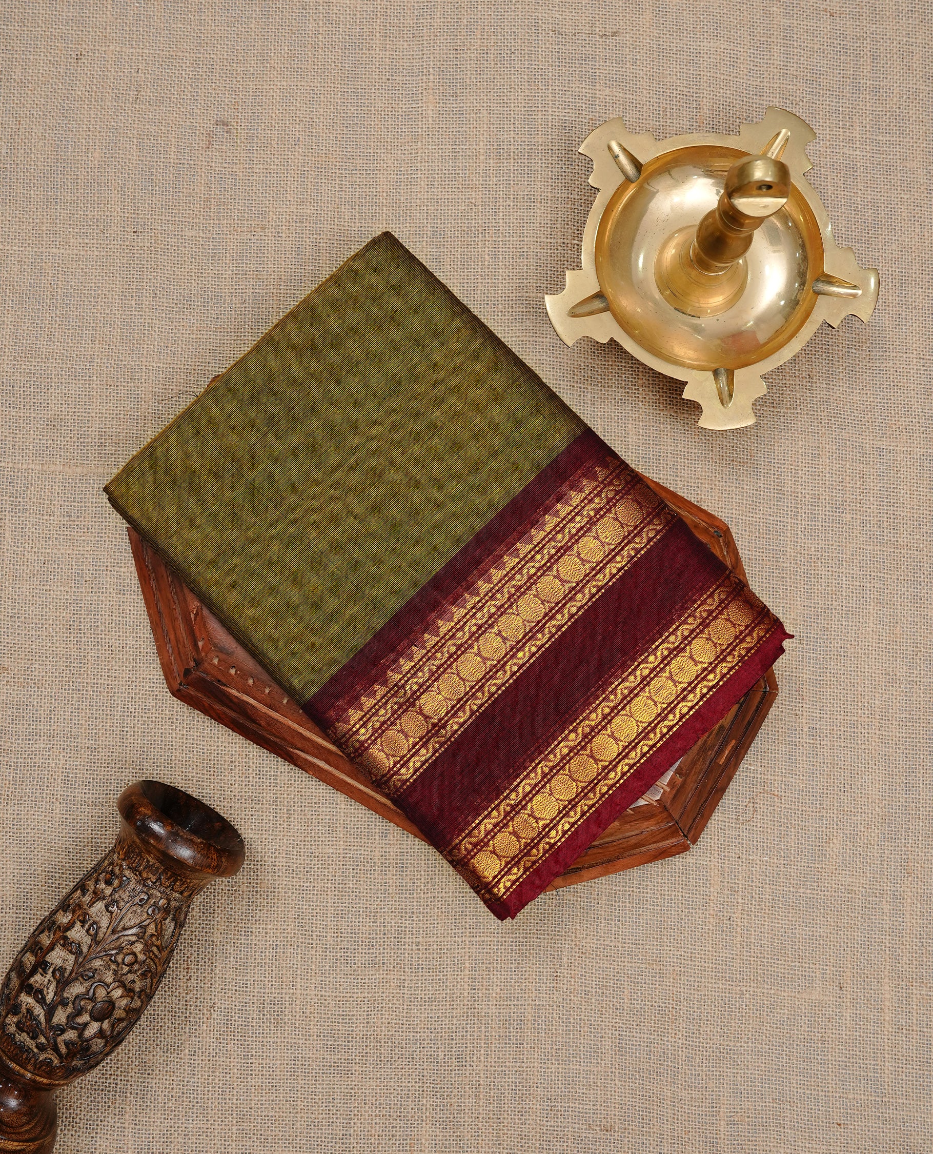 Dark olive colour Chettinad cotton saree featuring Elegant plain body, complemented by contrast Maroon colour with gold zari border, paired with matching blouse piece.