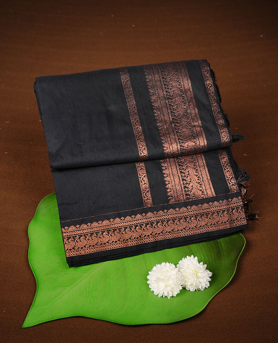Black colour kalyani cotton saree featuring Elegant plain body, complemented by selfcolour with Antique zari border, paired with matching blouse piece.