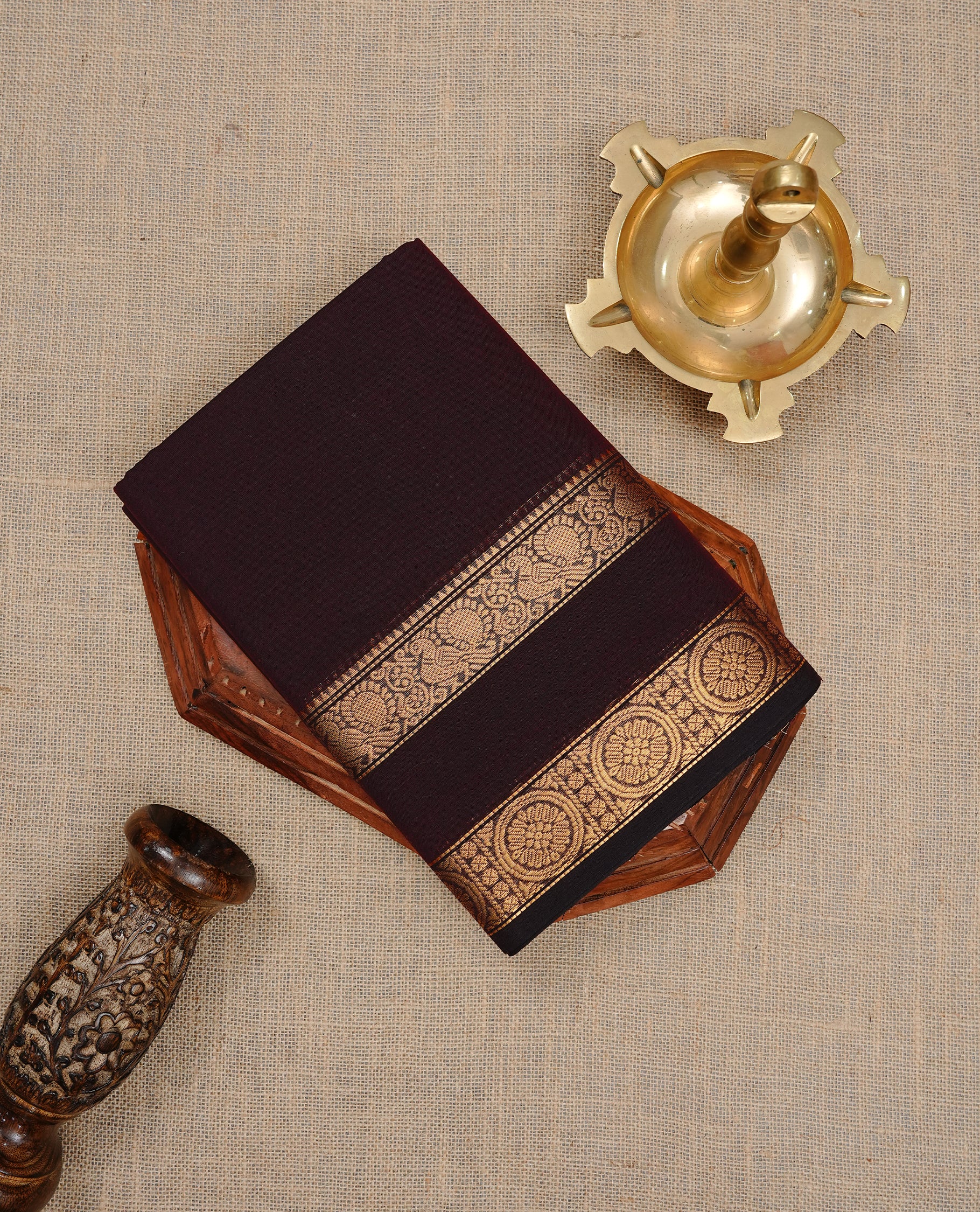 Dark chocolate colour Chettinad cotton saree featuring Elegant plain body, complemented by self colour with gold zari border, paired with matching blouse piece.