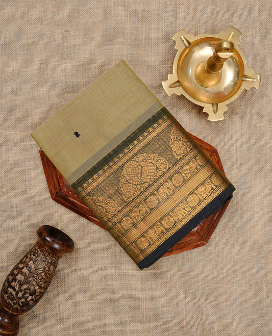 Greyish cream colour Chettinad cotton saree featuring motifs body, complemented by contrast Black colour with gold zari border, paired with matching blouse piece.